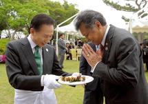 الرئيس الكوري الجنوبي لي ميونغ باك يقدم الطعام لأحد ضيوفه
