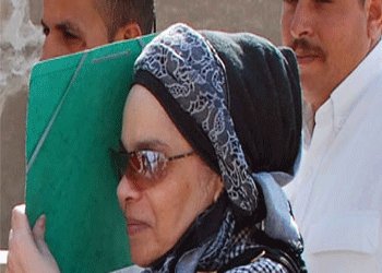 هدى عبد المنعم تحاول اخفاء وجهها عن كاميرات المصورين