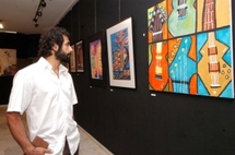 ماهر قريطم امام بعض لوحات معرض سابق