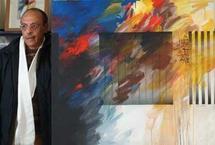 الرسام المغربي عبد الله الحريري امام احدى لوحاته