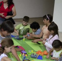 الأطفال الزائرون لمتحف فن ببيونس أيرس ويحيط بهم مجموعة من الأقلام الملونة وأدوات الرسم