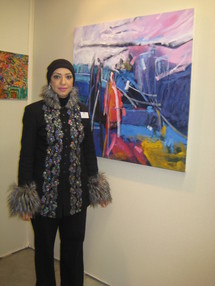 الفنانة القطرية امل العائم امام احد لوحاتها