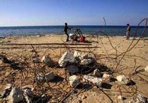 شباب فلسطينيون يجمعون حديد خردة وحصى من موقع مدمر على بحر غزة