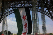 علم كبير للثورة السورية على برج ايفل وفرنسا تتهم الأسد بالتحضير لمجازر