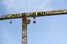 ناشطون من "جرينبيس" يعلقون لافتة ضخمة على رافعة ترميم نوتردام  
