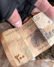 عملة سورية في ملابس أحد المرتزقة الروس بعد مقتله في اوكرانيا. عملة سورية في ملابس أحد المرتزقة الروس بعد مقتله في اوكرانيا.
