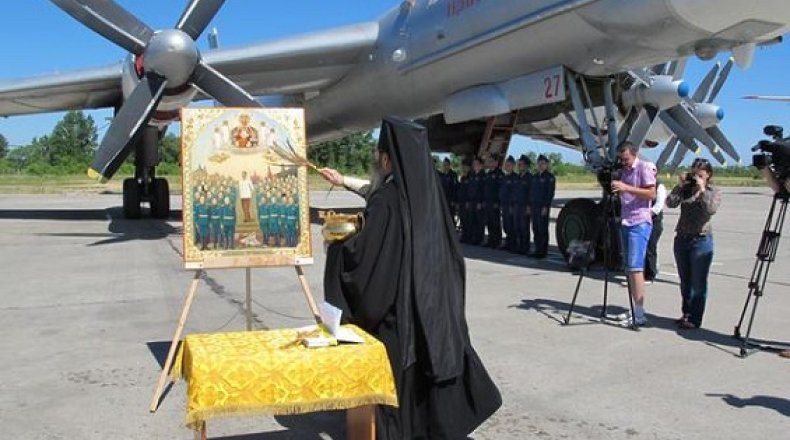 كاهن من الكنيسة الروسية يبارك الطائرات الروسية