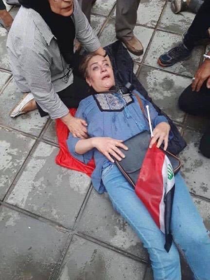 عراقية سقطت وعلمها بيدها