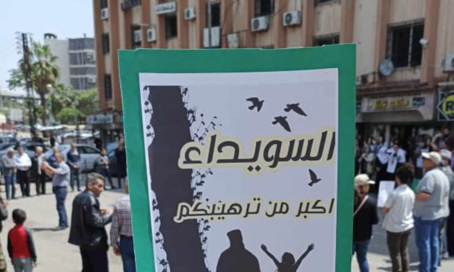 لافتة رجعها محتجون في مظاهرة وسط مدينة السويداء جنوبي سوريا - 1 من أيار 2024 (الراصد/ فيس بوك)