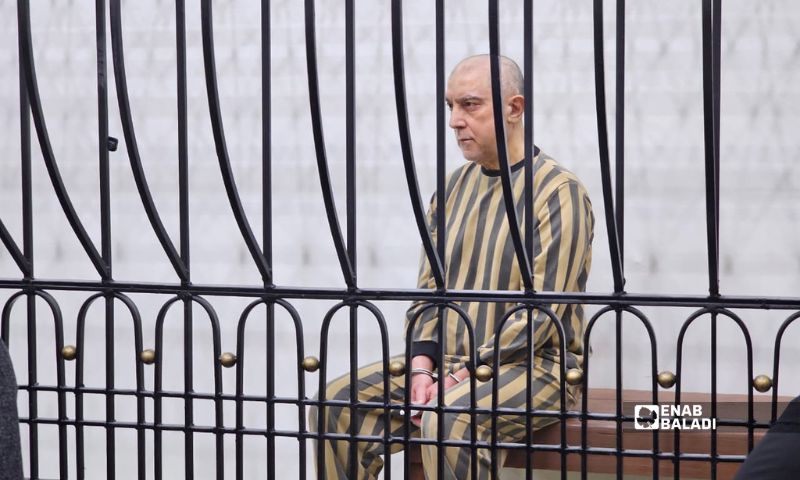 عاطف نجيب داخل قصف المحكمة خلال الجلسة الأولى من محاكماته - 26 نيسان 2026 (عنب بلدي/ أحمد مسلماني)
