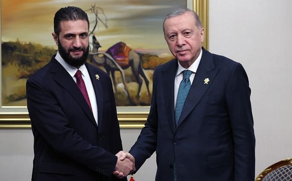 الرئيس السوري أحمد الشرع يصافح الرئيس التركي رجب طيب أردوغان في لقاء على هامش القمة العربية الإسلامية الطارئة بالدوحة - 15 أيلول 2025 (الأناضول)